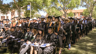 Rows of students in caps and gowns during a commencement ceremony.