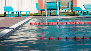 A pool-level image of the New Mexico Tech Swimming Center. Lane markers can be seen in the water.