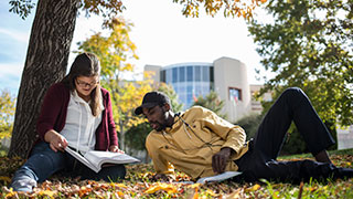 Image of two students studying outside