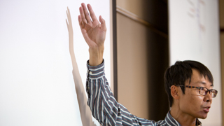 Close up image of a professor at a whiteboard.