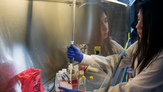 Female latina student working on a Chemistry experiment.