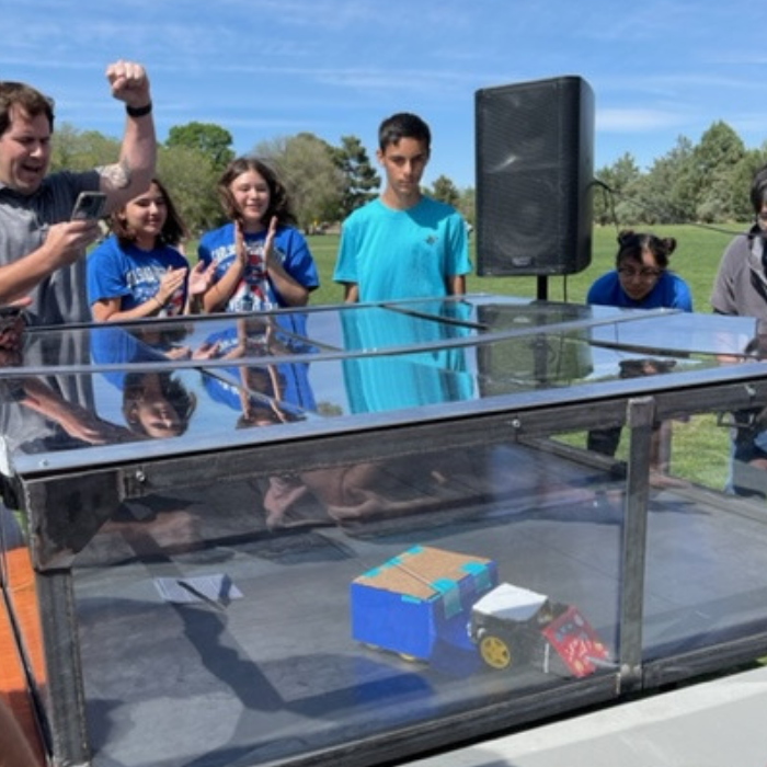 Students cheering for a robot.