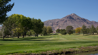 Image of "M" Mountain as seen from the NMT Golf Course. The green grass of the golf course is seen in the image foreground.