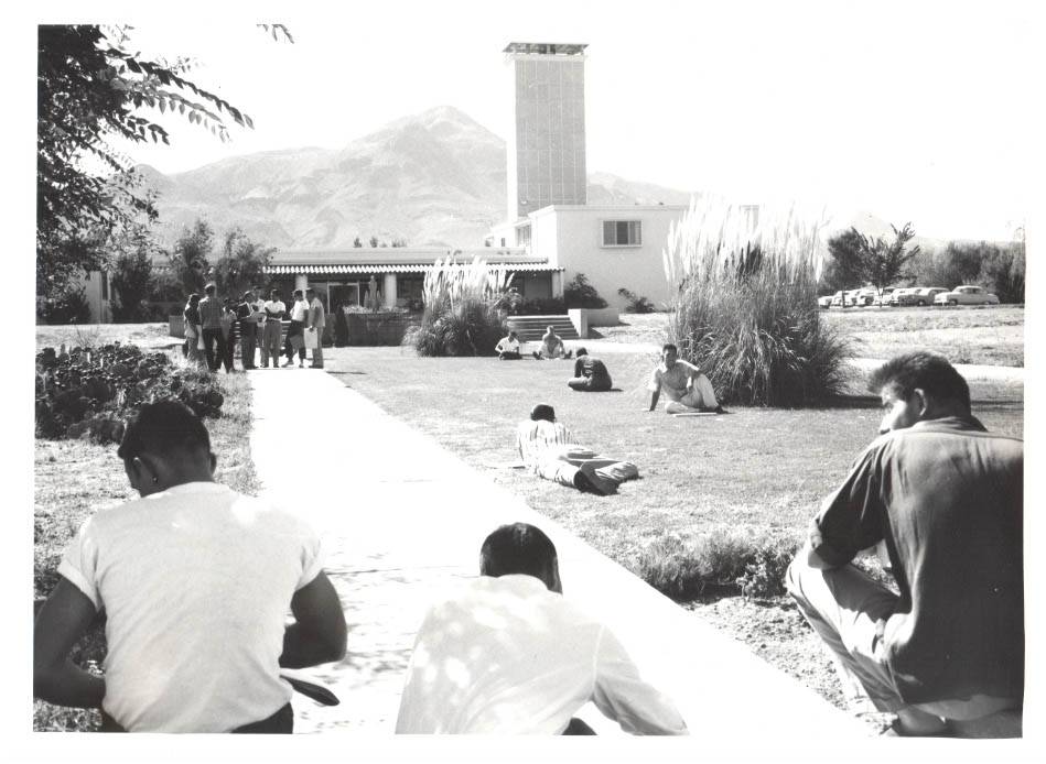 Historic image of NMT's Workman Center entrance with students lounging on campus grounds