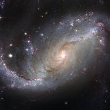 Spiral galaxy with dust and stars; center of the galaxy is very luminous