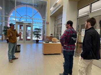 Matthew Zimmerer, Ph.D., field geologist and adjunct professor with the New Mexico Bureau of Geology and Mineral Resources, left, tells potential New Mexico Tech Earth and Environmental Science program graduate students that the Mineral Museum and bookstore are really great resources to learn about New Mexico geology. Zimmerer led a tour of the bureau’s building Friday, March 4.