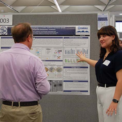 Ashley, a graduate student in Biology, explaining her project to Dr. Simpson, one of the judges