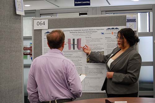 Here we see Mariana explaining her project titled,  "Separating the Inseparable: Kinematic Recoil as a Separation Method for Chemically Identical Isotopes," to Dr. Simpson, one of the judges in the GSA Poster Competition. 