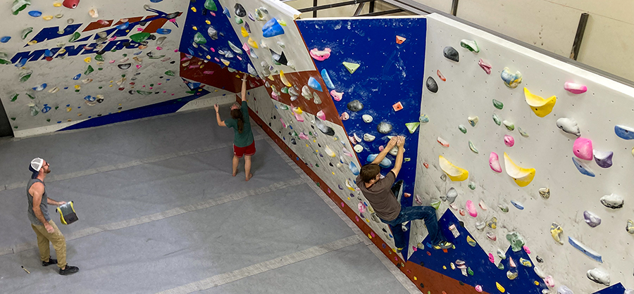 View of students at the bouldering wall in the NMT gym