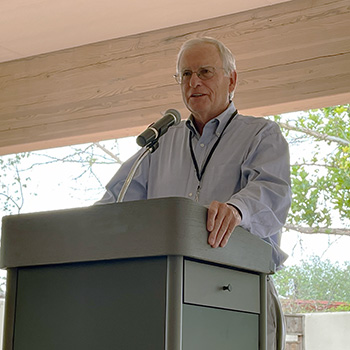Dr. John Wilson speaking at a podium